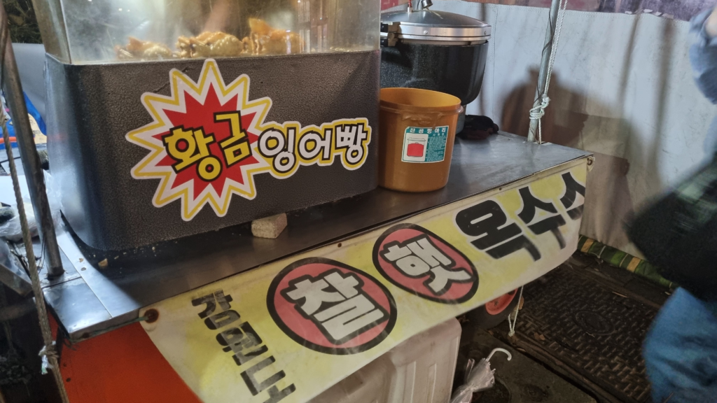 Bungeoppang and roasted corn street vendor pojangmacha selling Korean winter snacks