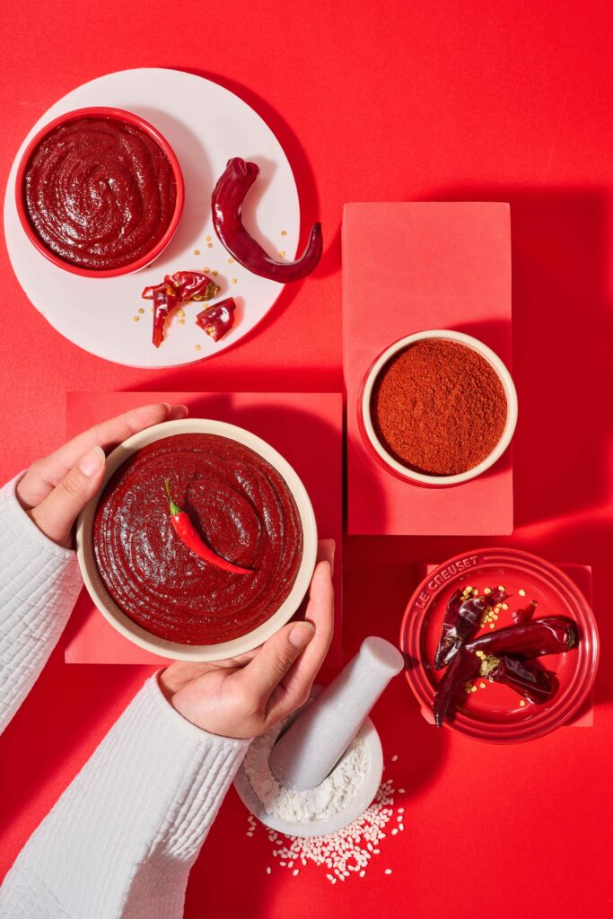 Korean gochujang fermented chili paste with red chili peppers and gochugaru showing ingredients and texture