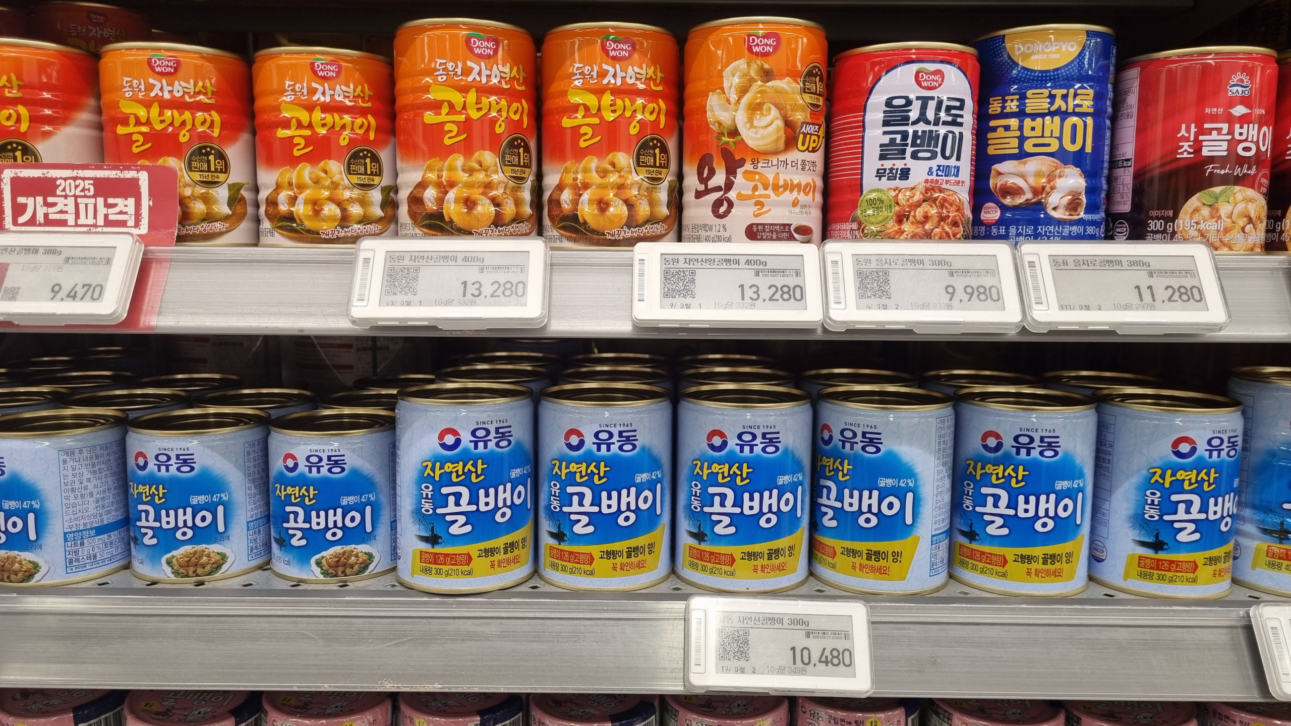 Canned golbaengi (Korean sea snails) on supermarket shelf in Seoul - blue Yudong brand natural sea snails, primarily imported from British fisheries