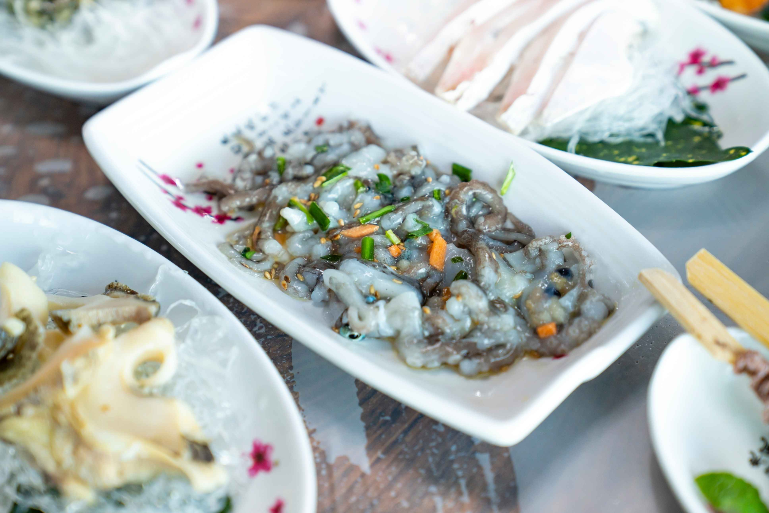 Sannakji (live octopus) served as main dish on Korean sashimi platter with assorted raw fish and side dishes