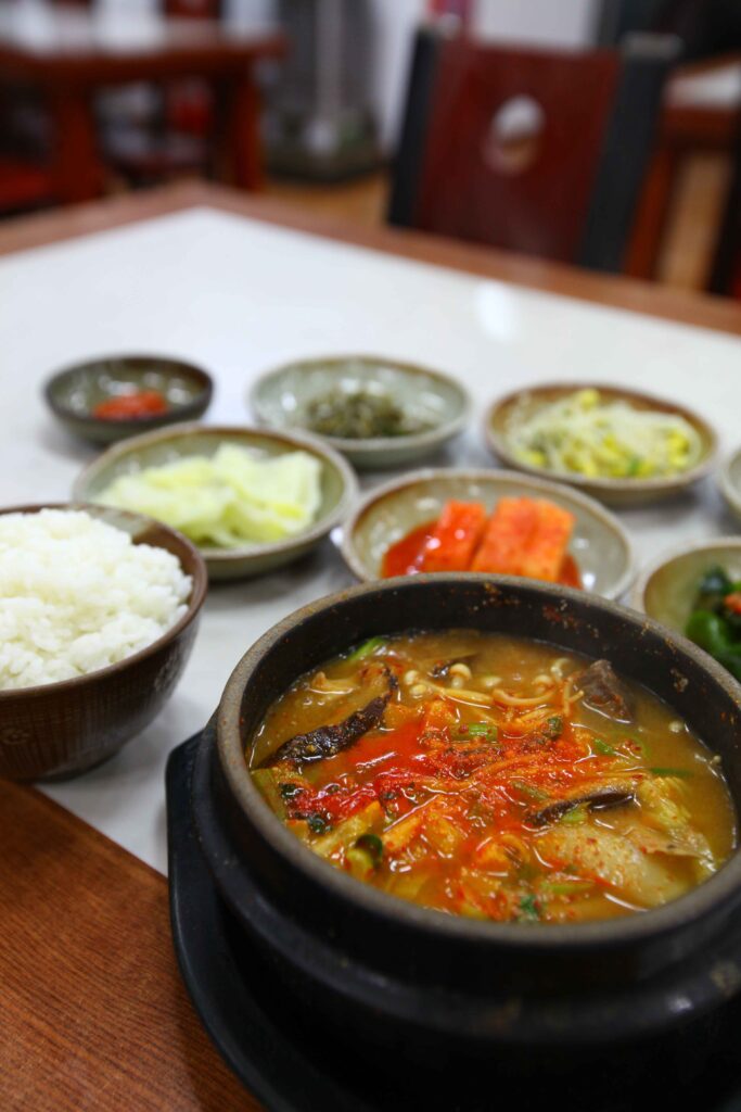 Doenjang jjigae (된장찌개) served in a stone pot with rice and banchan side dishes — Korea's most common everyday use of doenjang