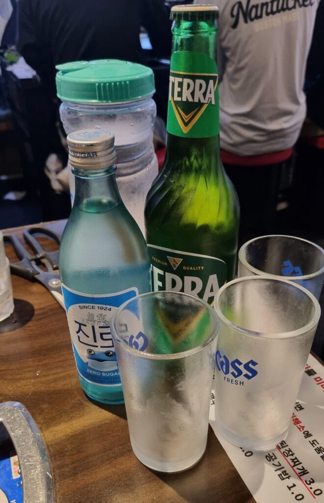 Jinro soju and Terra beer on a Korean restaurant table with shot glasses