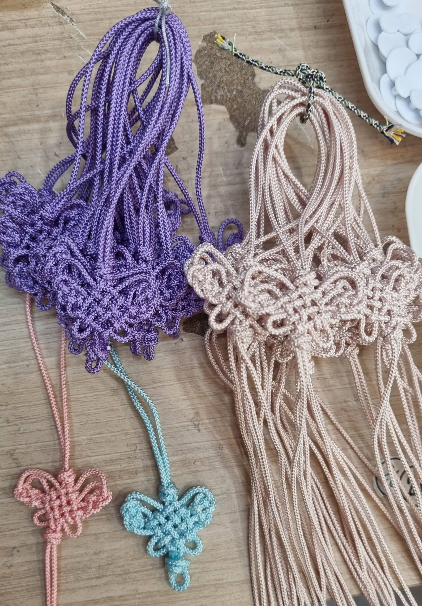Korean maedeup butterfly knots and norigae cords in purple, pink, and blue at a traditional craft workshop in Korea