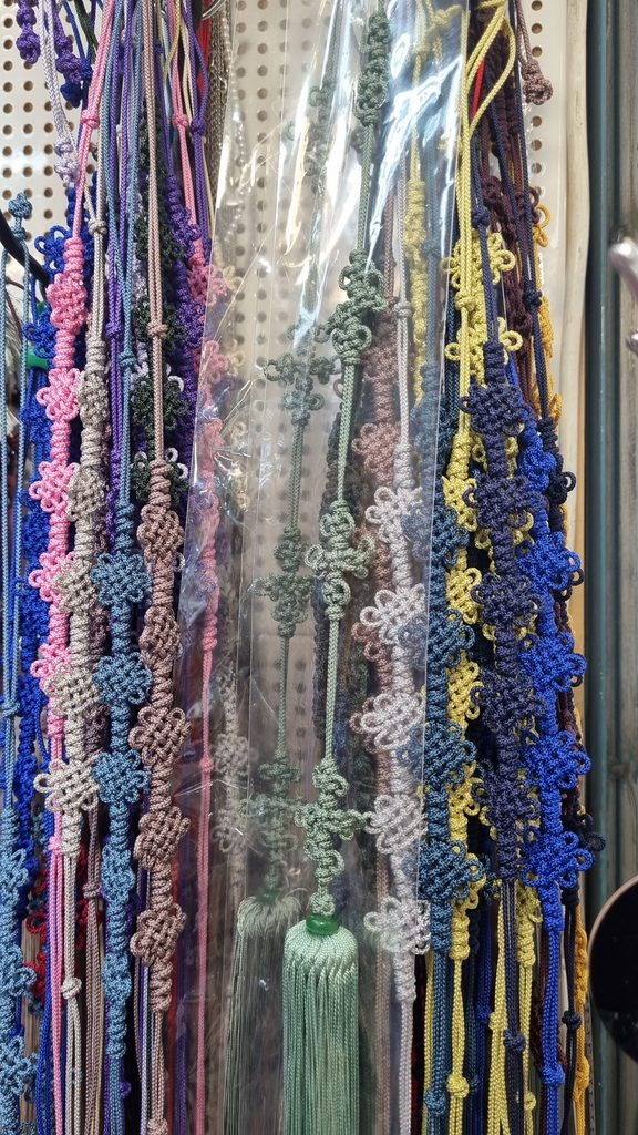 Rows of Korean maedeup norigae cords in many colors hanging at a traditional craft market in Seoul