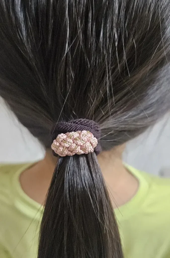 Korean maedeup knot hair tie in pink worn in a ponytail, showing how the knot sits on the elastic