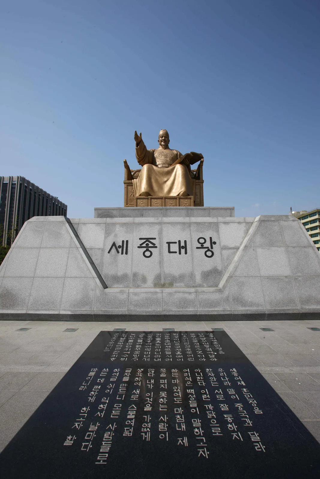Gilded King Sejong statue at Gwanghwamun Plaza with the Hunminjeongeum preface carved into the ground before it